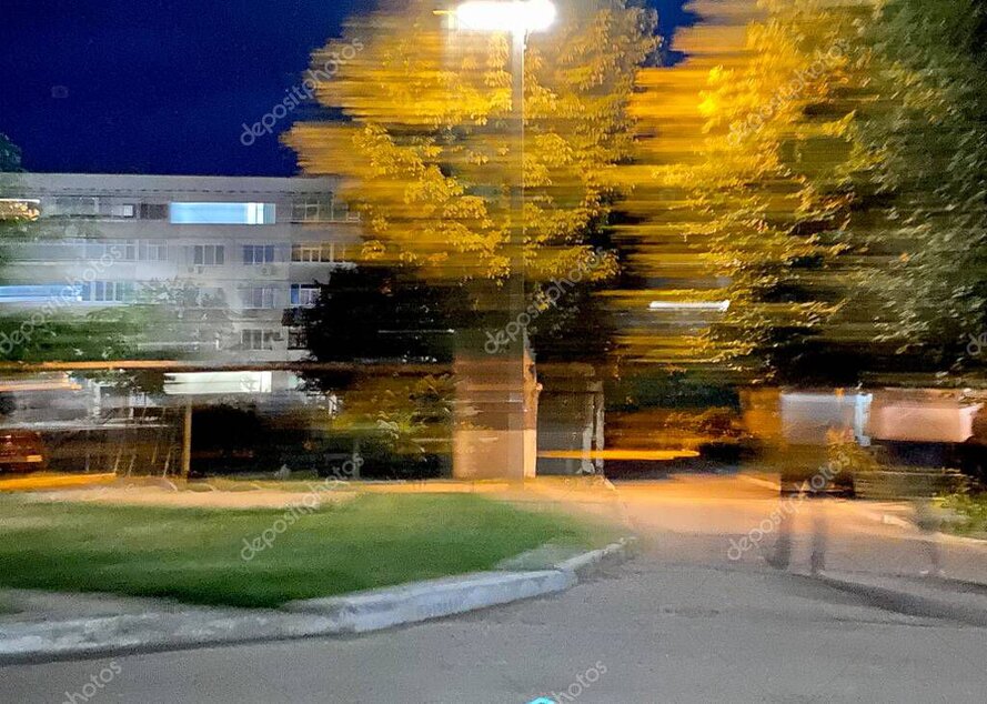 Klinikgebäude mit beleuchtetem Eingang und Videoüberwachung bei Nacht